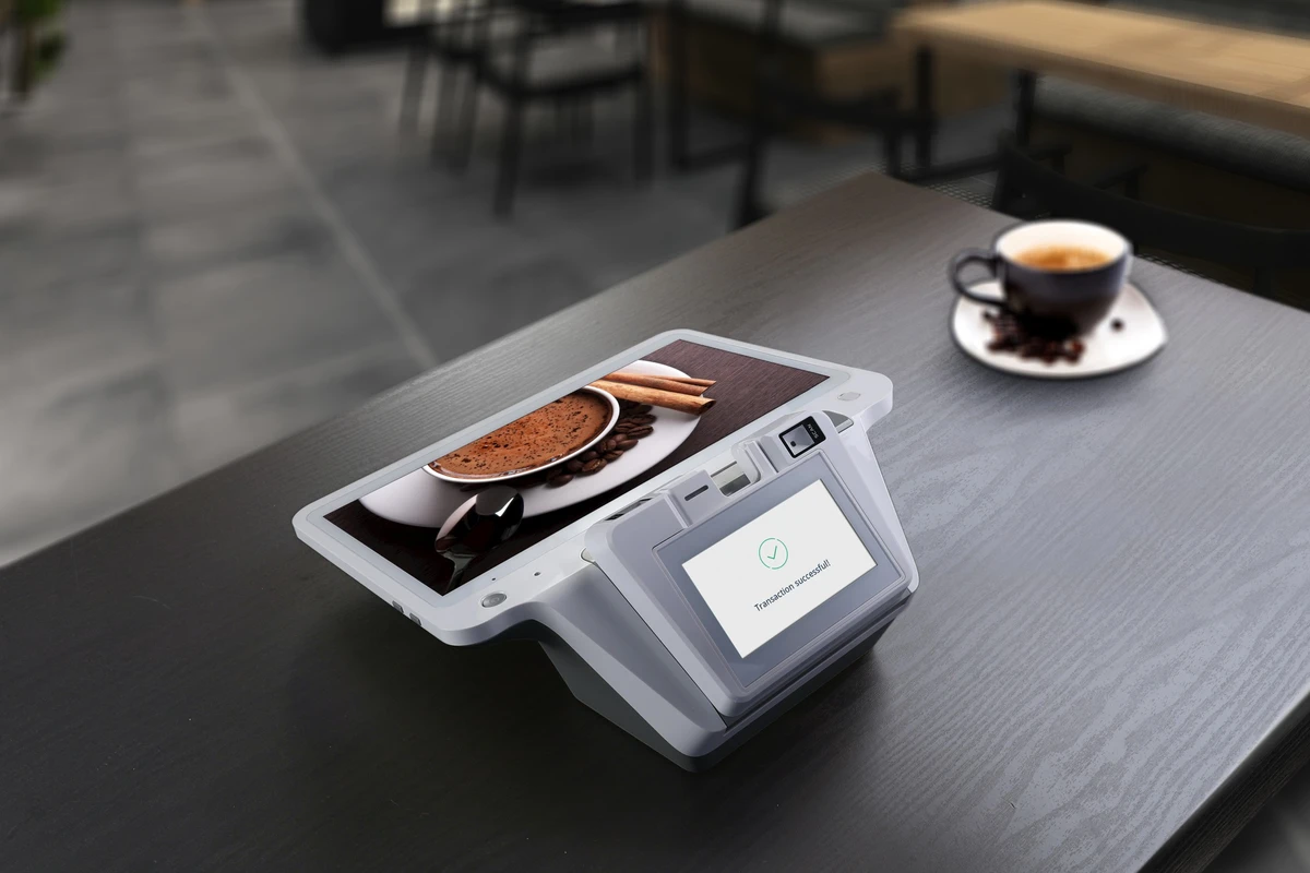 PAX E700 SmartPOS deployed on coffee shop counter with customer-facing PIN display